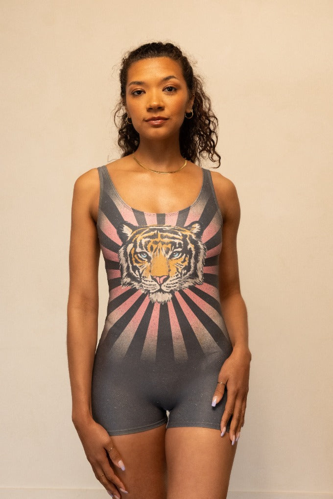 Woman wearing a gray tank top with a tiger design on a beige background