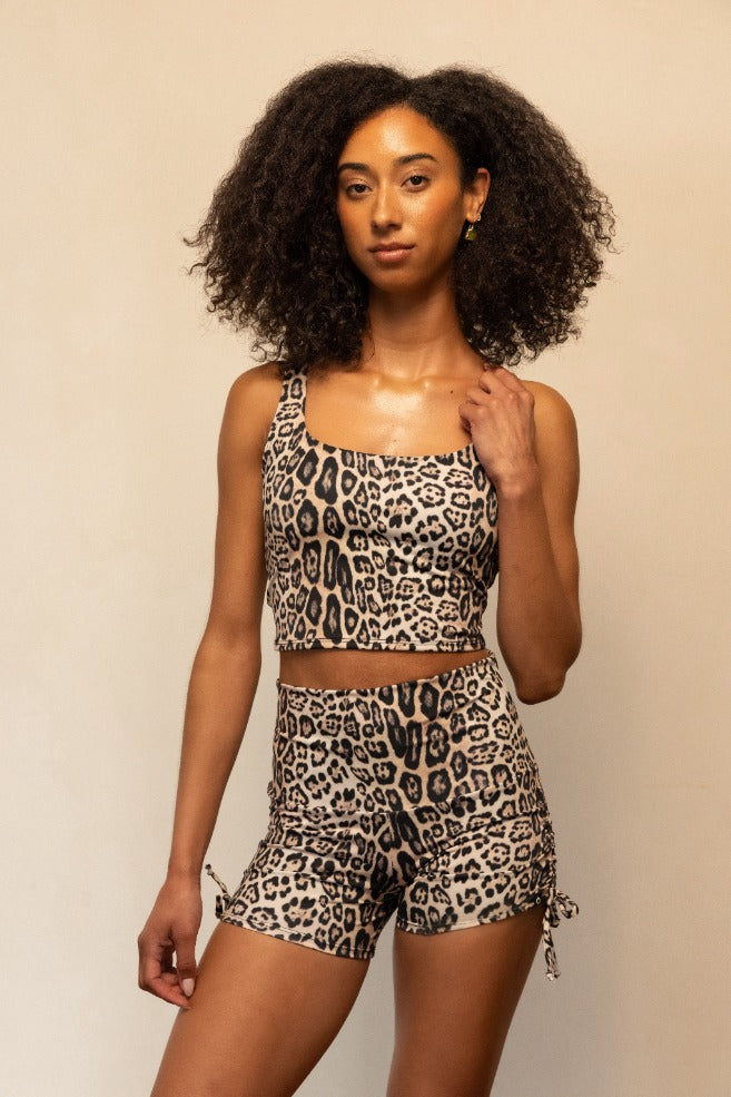 Woman wearing a leopard print outfit against a beige background