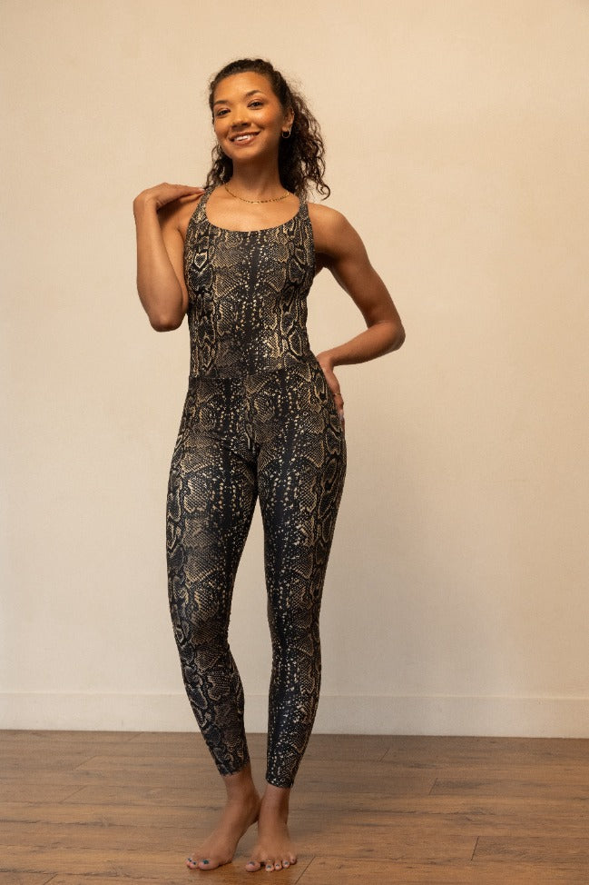 Woman wearing a patterned jumpsuit against a plain background